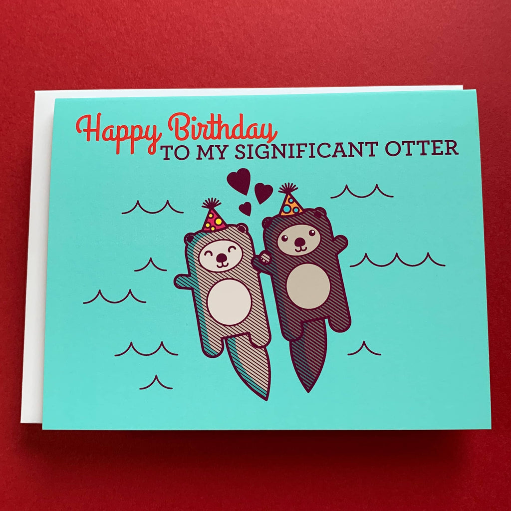 birthday card with two otters holding hands and wearing little birthday party hats