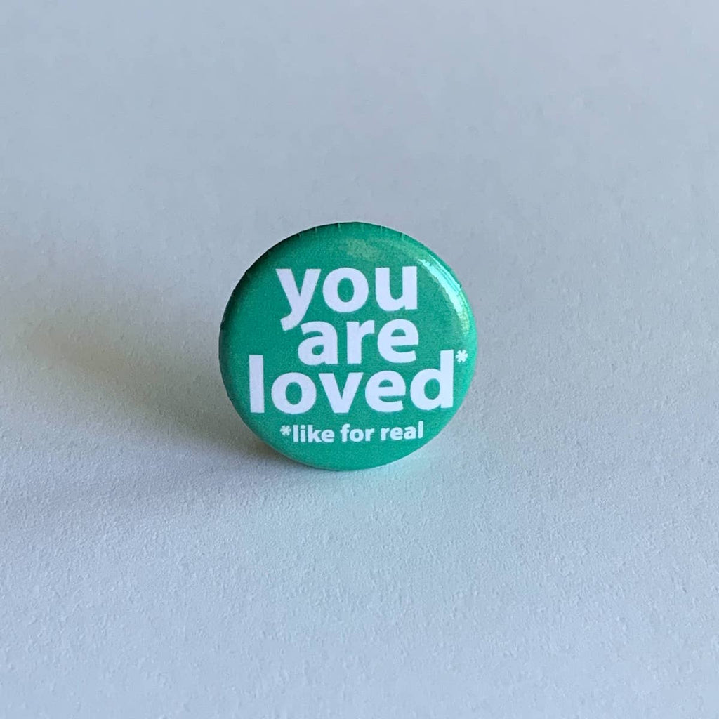 teal button with you are loved in white letters