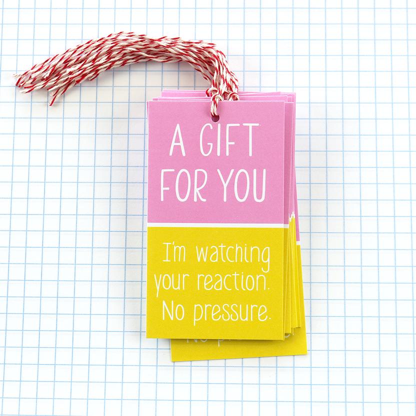 Gift tag with pink box and yellow box on grid paper backdrop