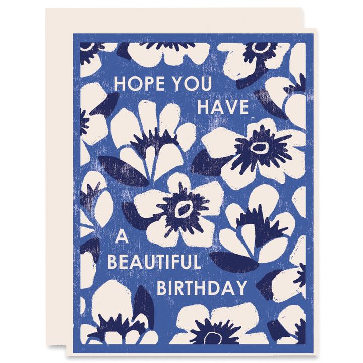 Birthday card with blue background and white flowers with dark blue centers